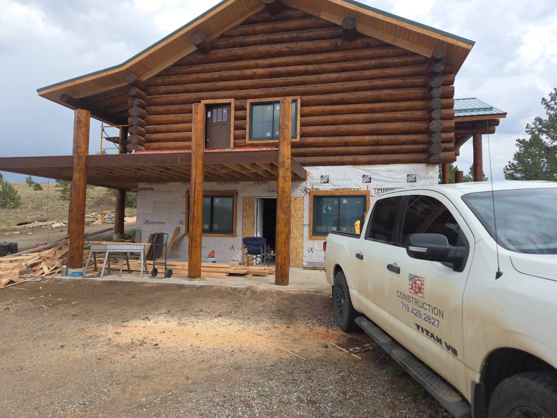 Log cabin exterior stained by A1M Construction with the A1M truck on site