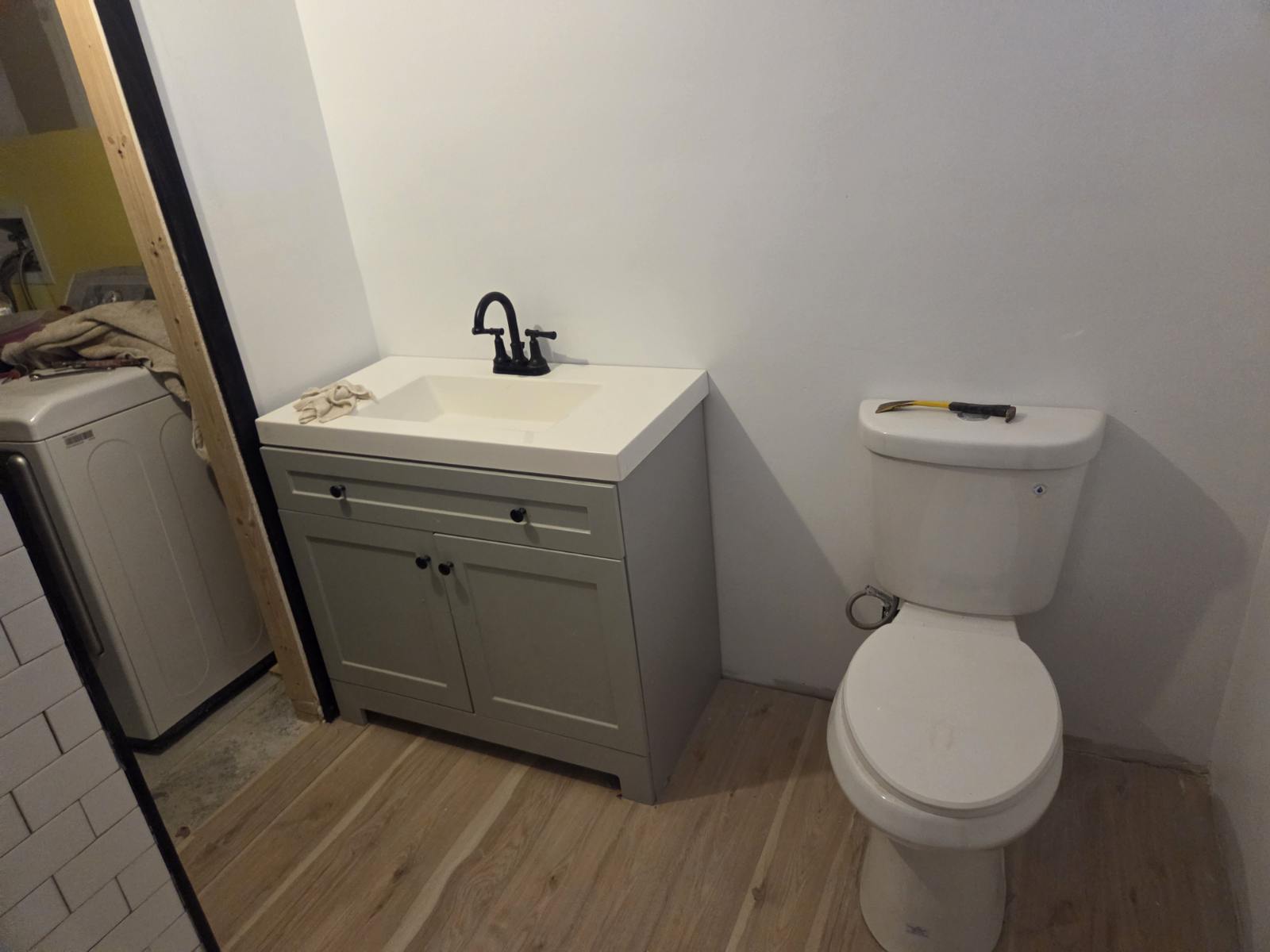Bathroom with new wood-look flooring and vanity installed by A1M Construction